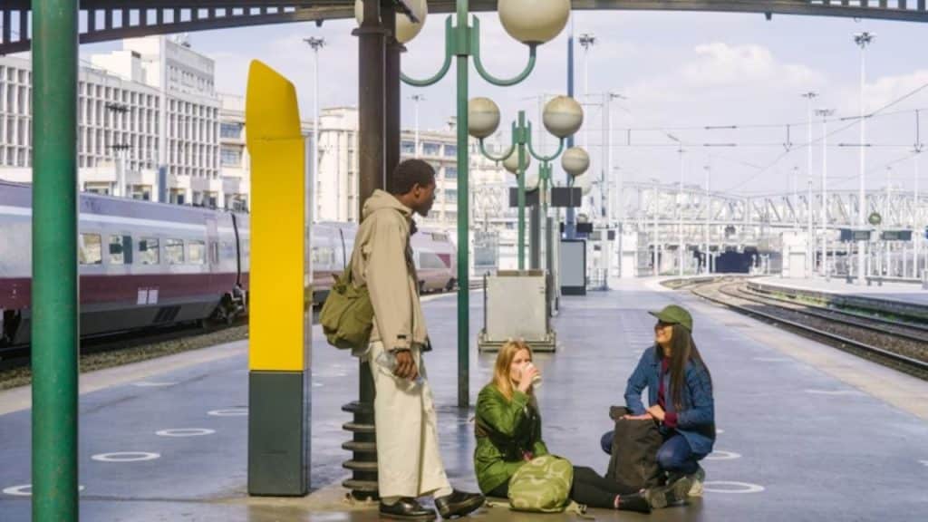 Woman helping someone, while her partner watches admiringly.