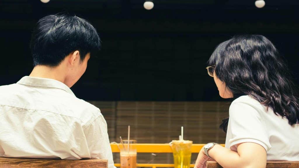 A couple talking over drinks.