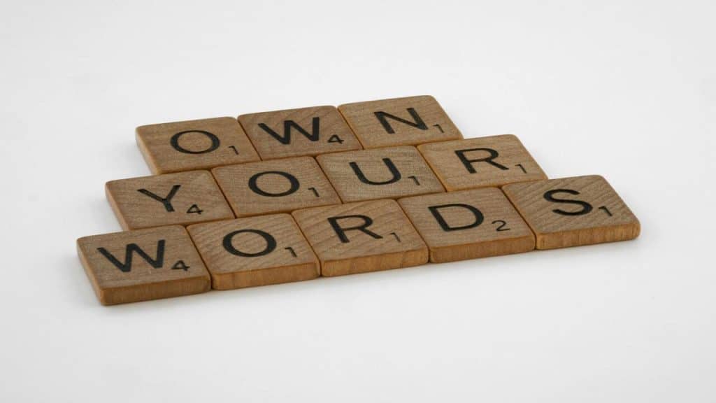 Scrabble letters spelling out “own your words”.