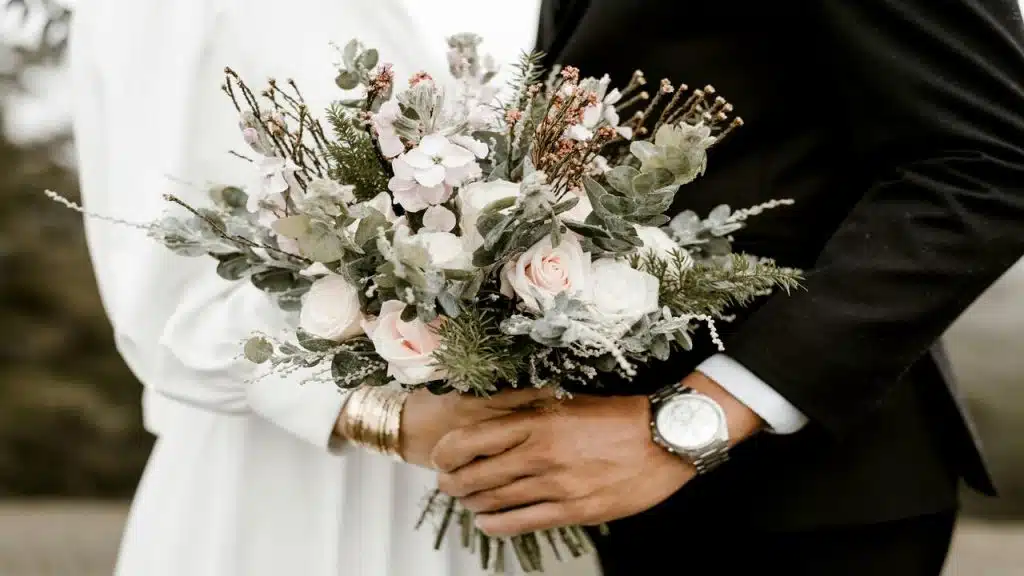 Bride and groom holding wedding bouquet.