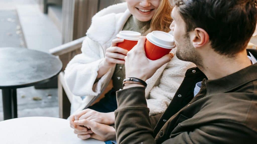 A couple talking while having coffee.
