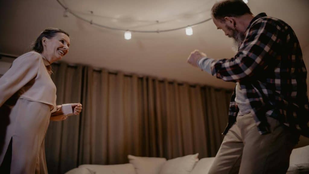 A couple laughing together while dancing.