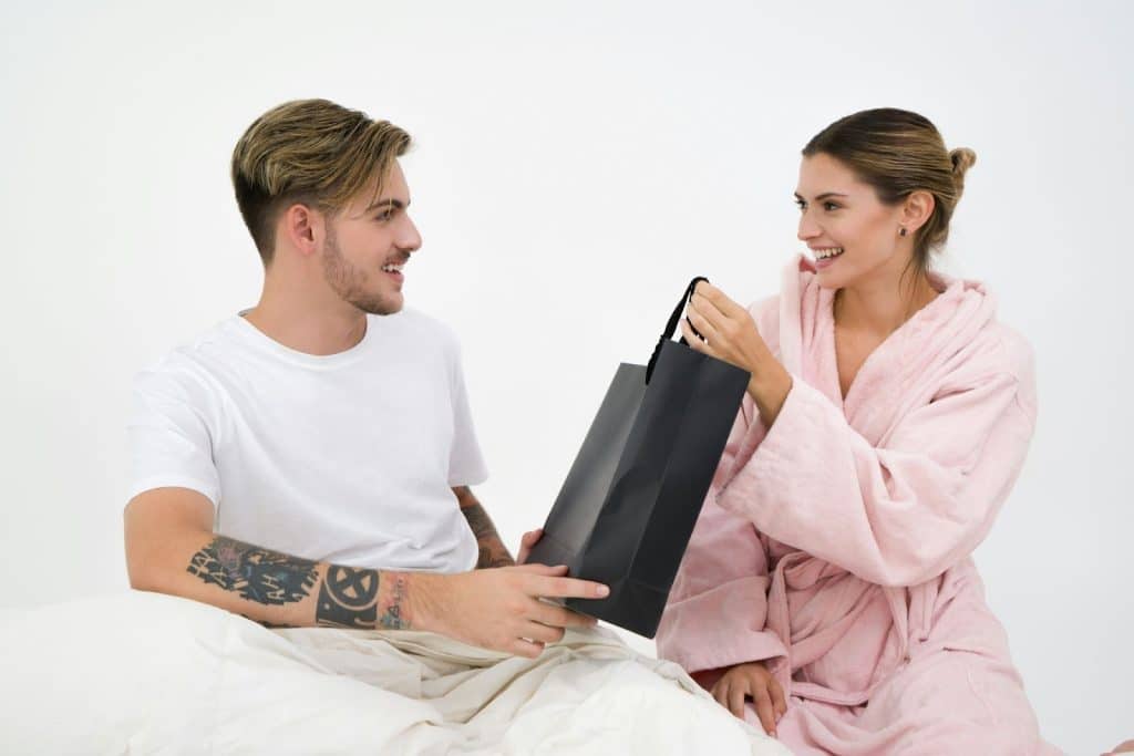 A woman giving a gift to a man
