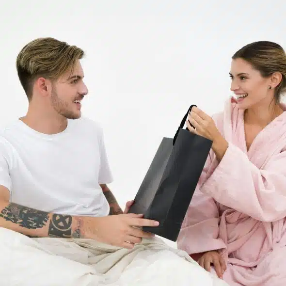 A woman giving a gift to a man