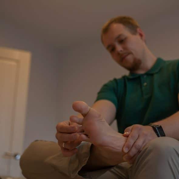 A picture of a person holding his foot