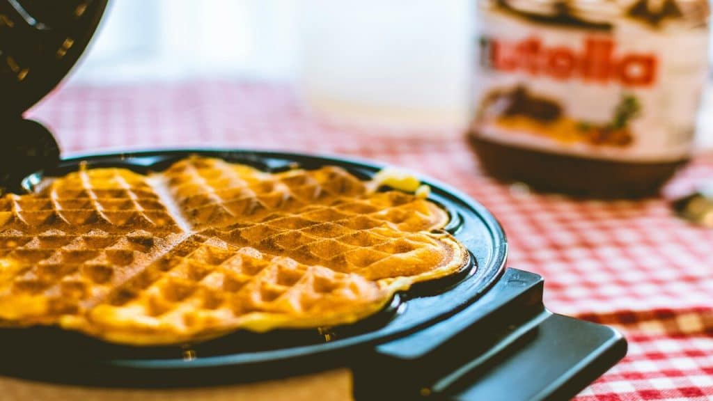 A waffle maker with a waffle cooking.