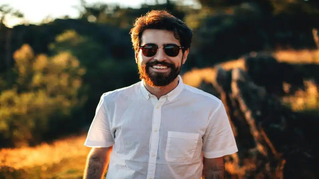 A man wearing sunglasses and smiling at the camera
