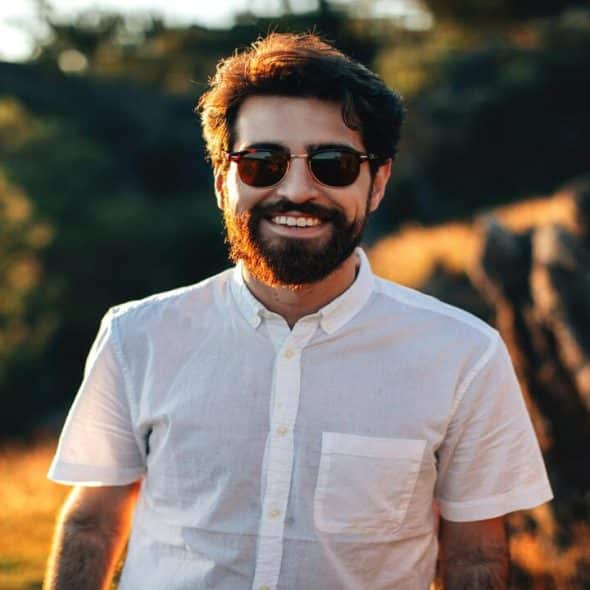 A man wearing sunglasses and smiling at the camera