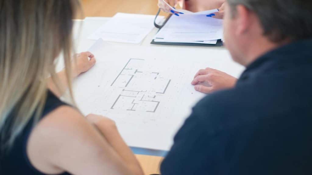 A man and a woman looking at a floor plan