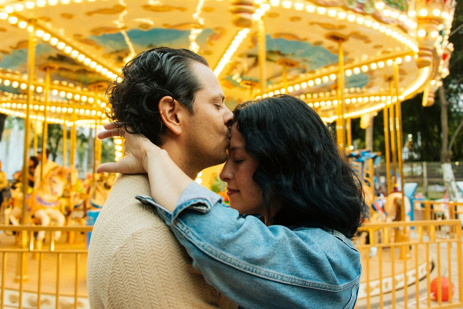 A man kissing a woman’s forehead.