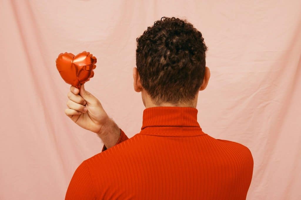A man holding a small heart balloon
