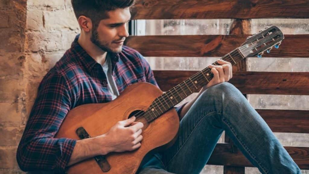 Man playing guitar or practicing a hobby alone.