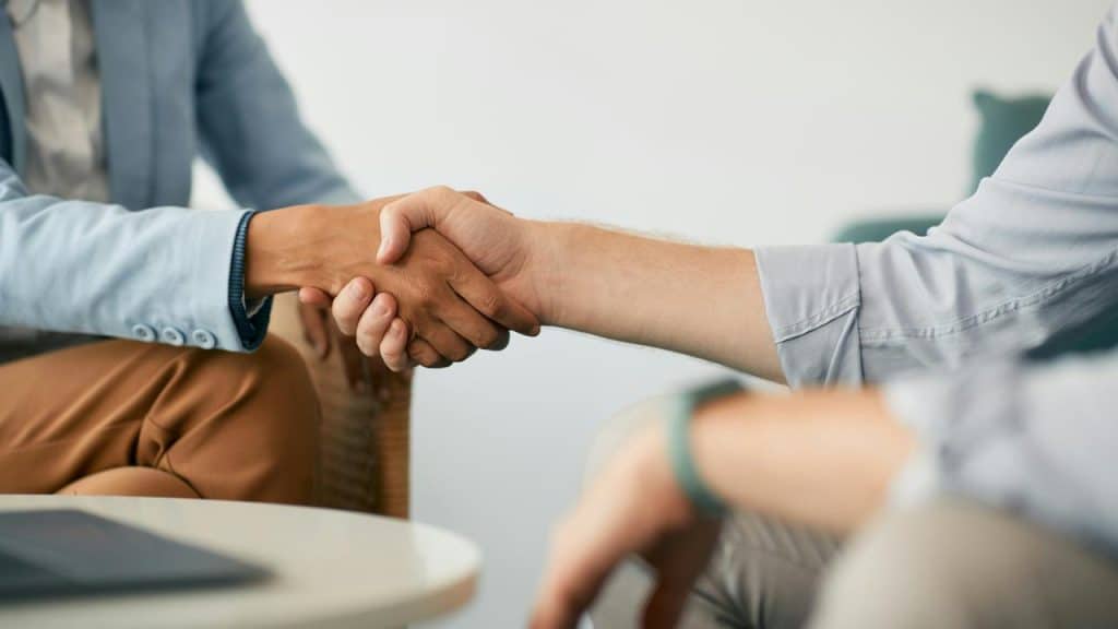 A handshake between two professionals at work.