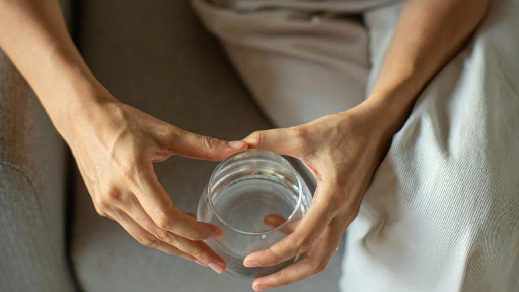 A person holding a glass of water.