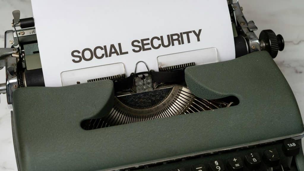 A typewriter typing the words “SOCIAL SECURITY” on a sheet of paper.