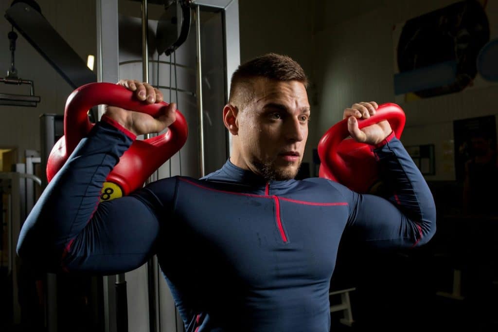 A man lifting heavy kettlebars