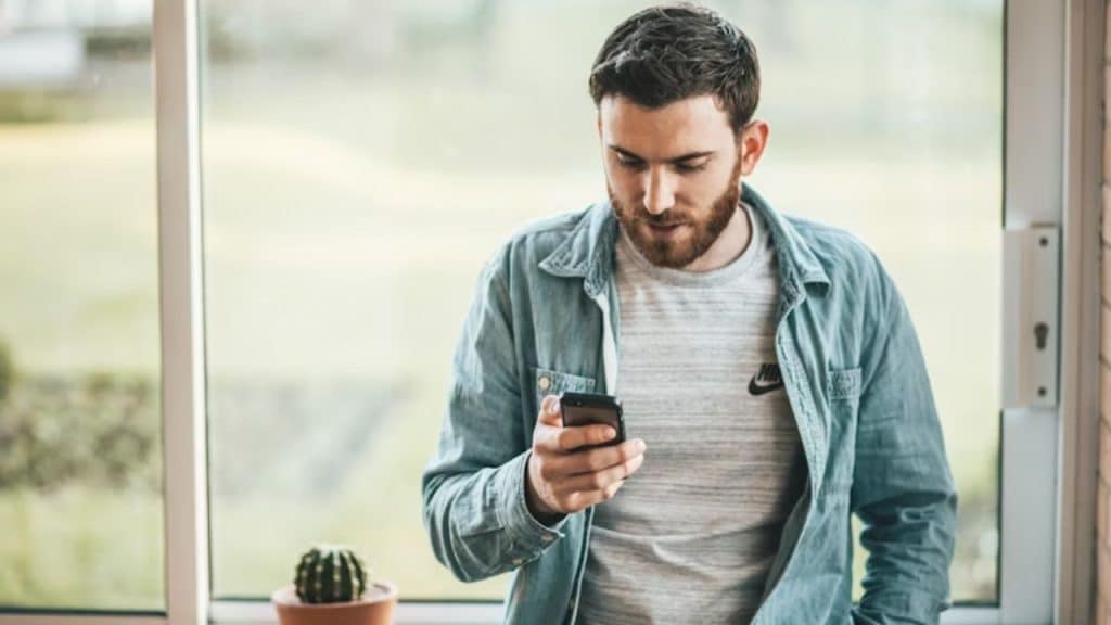 Man comparing his relationship to others on social media with mixed emotions.