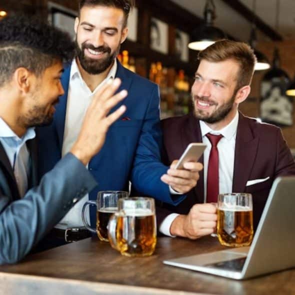 Man politely declining a drink offer at a bar after work.