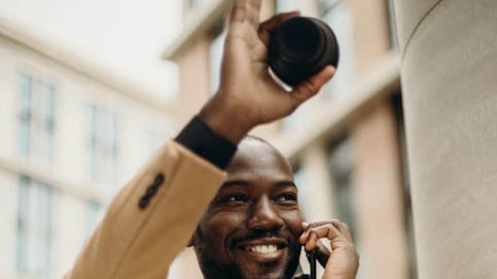 Man in business casual waving off a drink offer politely.