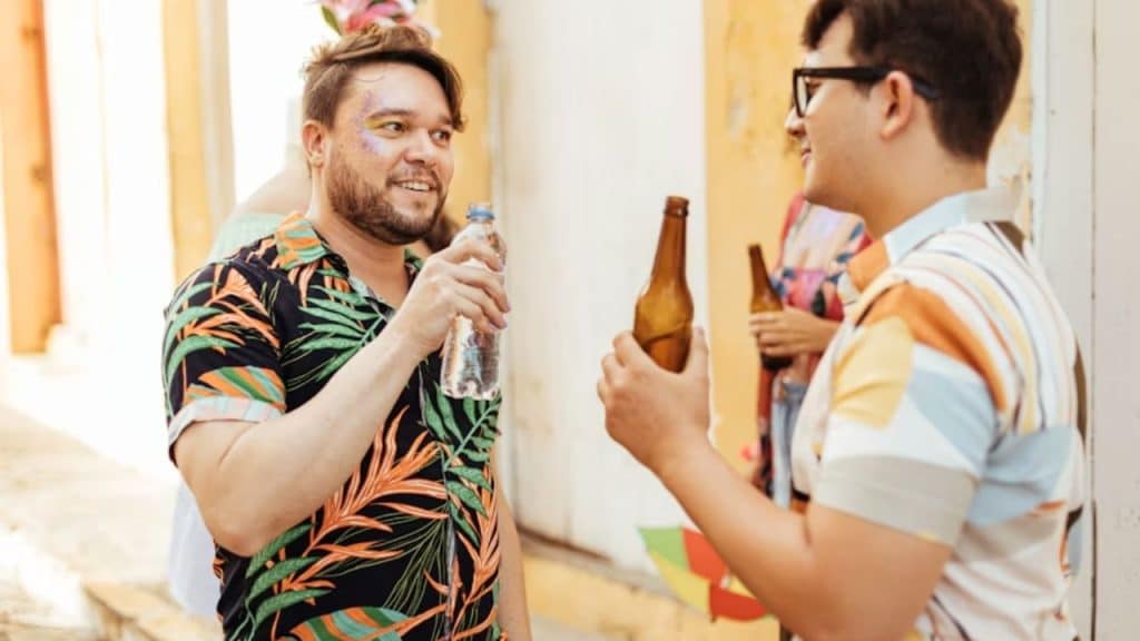 Man laughing while raising a water glass instead of alcohol.