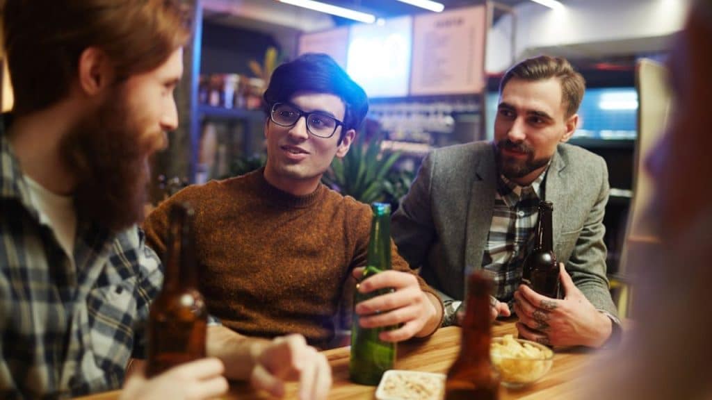 Man holding a soda water at the bar, staying clear headed.