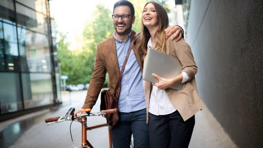 Man and woman strolling outdoors, smiling in a relaxed non work environment.