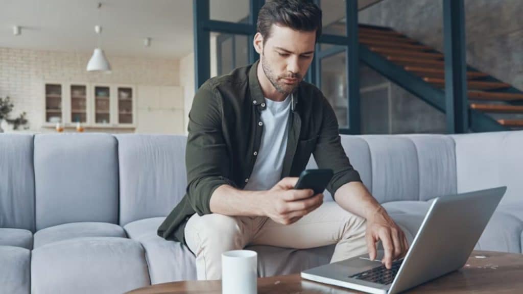 Man scheduling personal time on smartphone next to work plans.