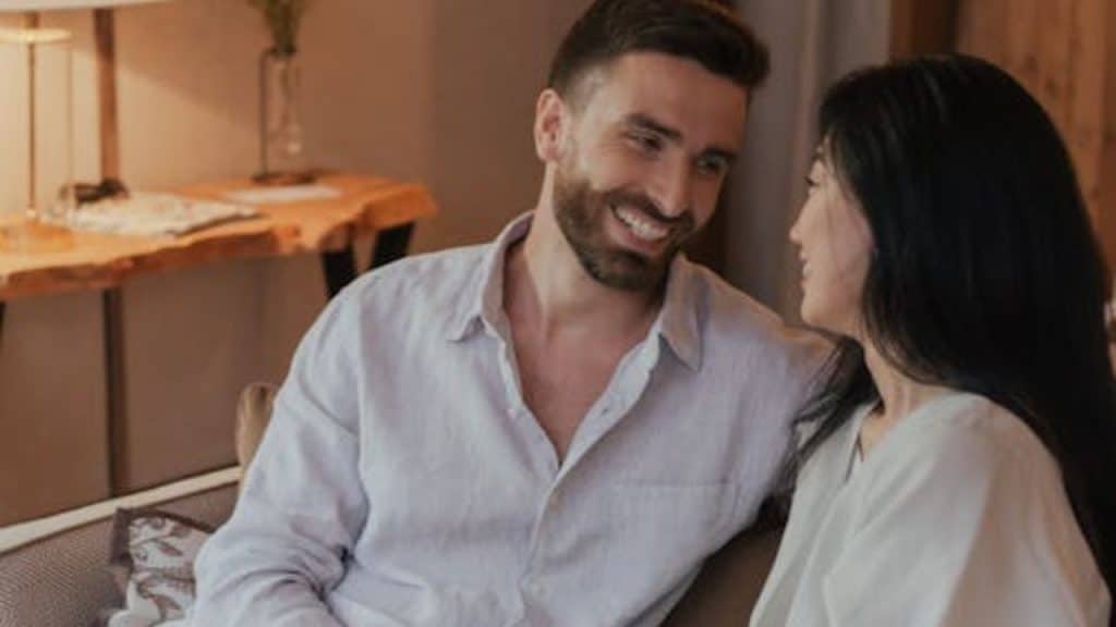 Couple relaxing on a couch with no devices in sight.