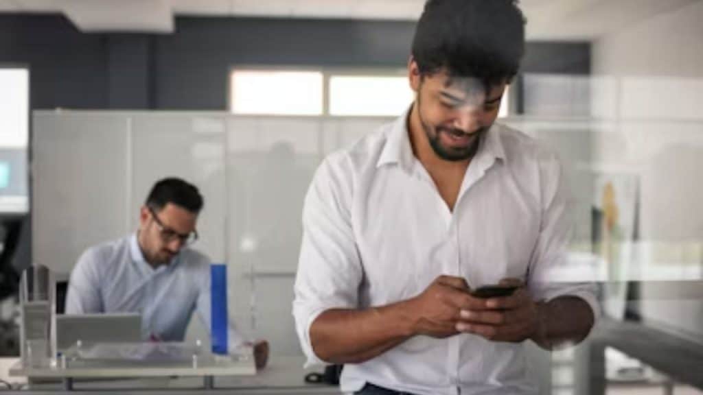 Man sending thoughtful text message during work break.