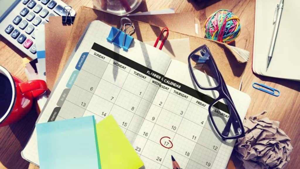 Planner calendar and notepad on the table for work tasks and relationship moments.