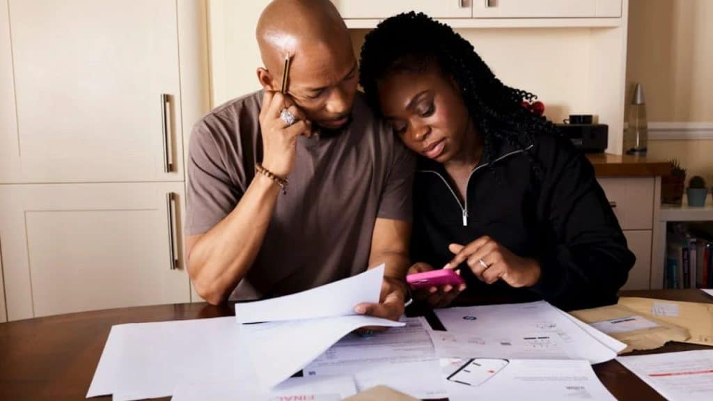 Man discussing financial concern calmly while listening to his partner.