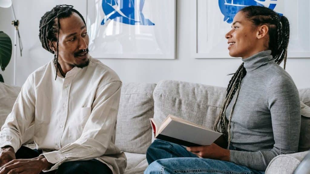 Couple smiling, speaking gently during a serious conversation.