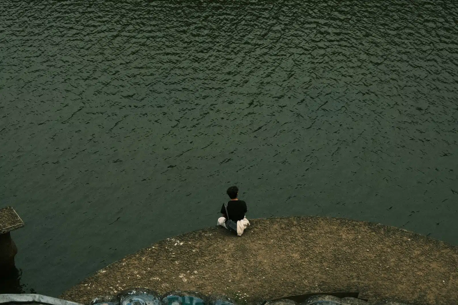 A man sitting alone on the edge.