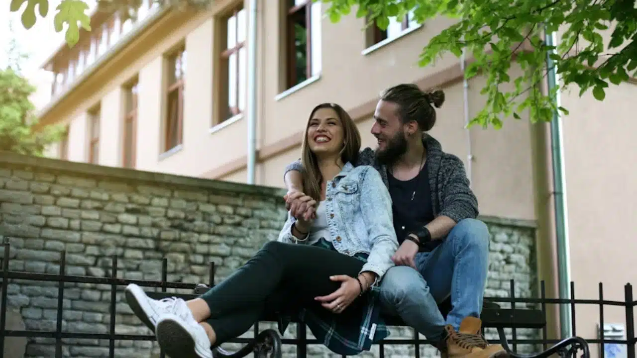 Couple sitting peacefully on a park bench enjoying a calm, silent moment together in nature.