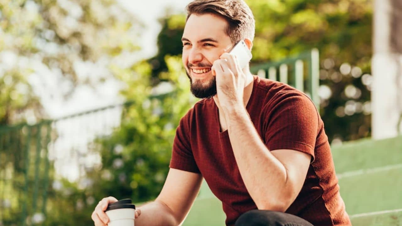 Man feeling happy while talking to his partner on the phone.