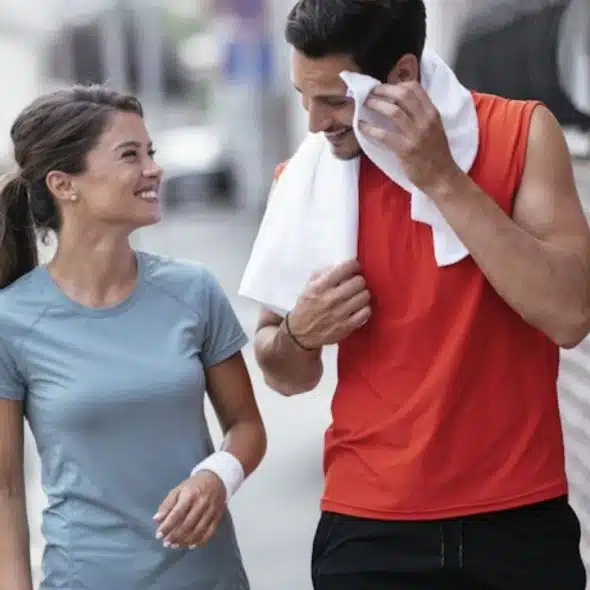 Man and woman after workout, with the man visibly more drenched in sweat