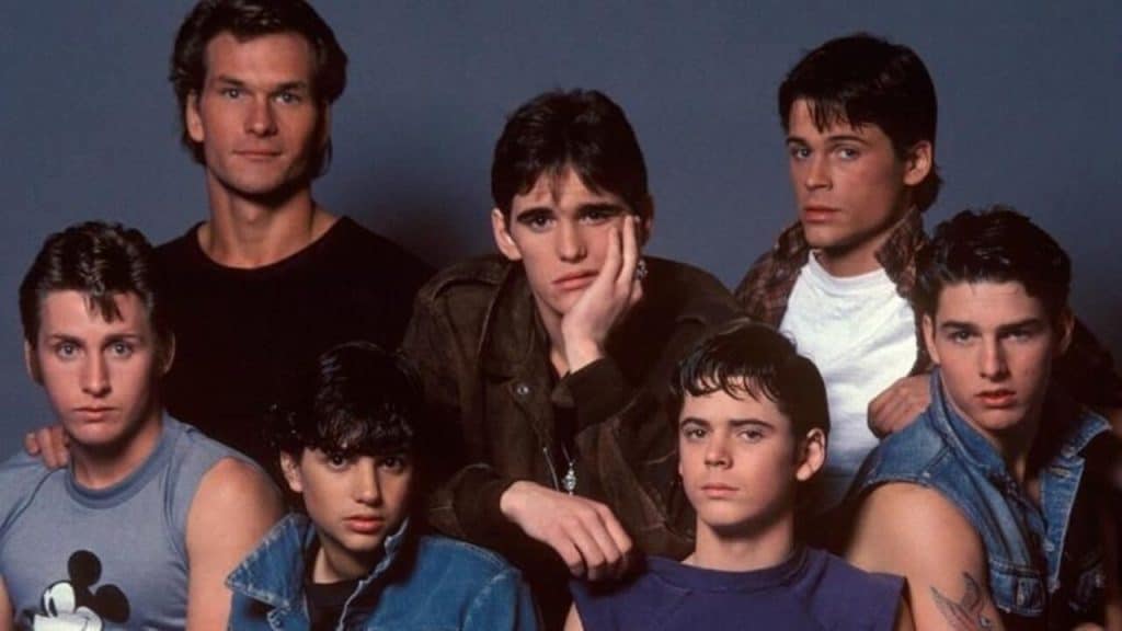 A group of teenagers from the 80s posing for the camera.