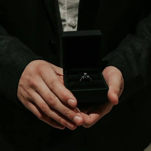 A person holding a ring on a box