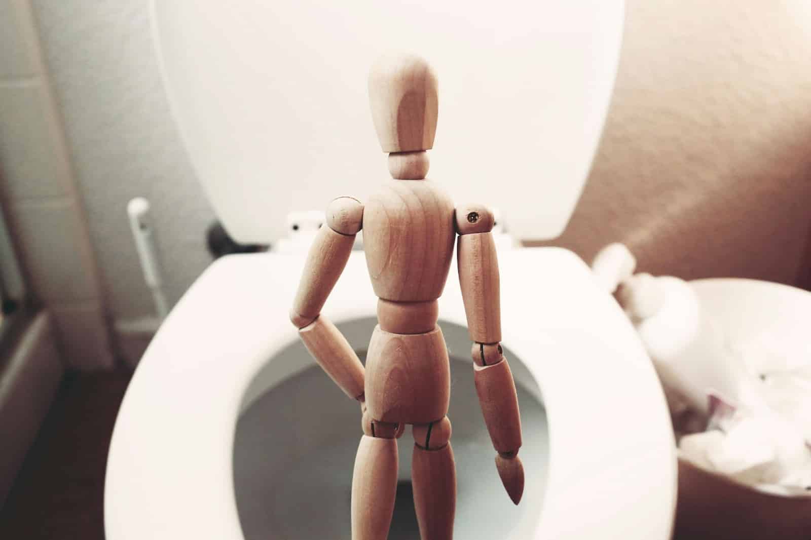 A figure in front of a toilet bowl.
