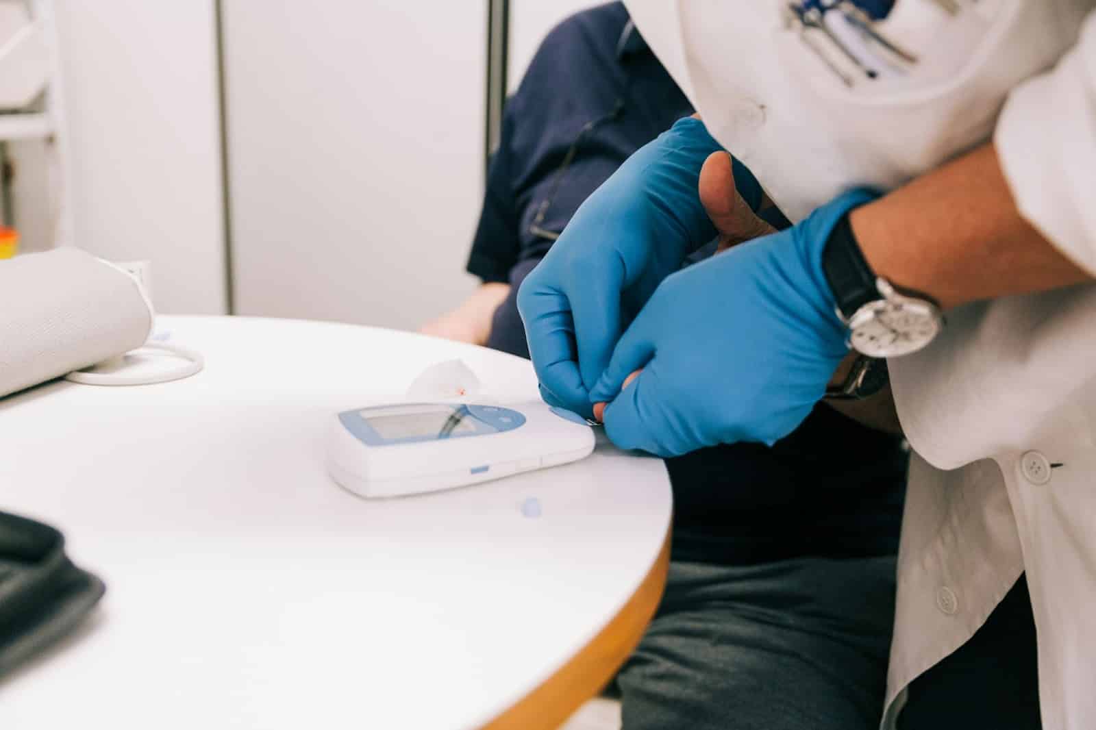 A man getting his blood sugar check with a nurse.
