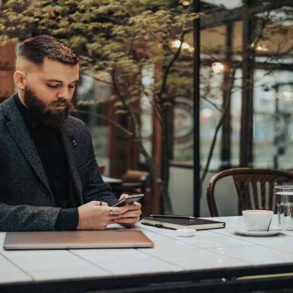 A man using a smartphone in the cafe.