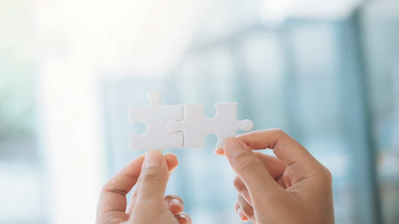 A person putting two puzzle pieces together.