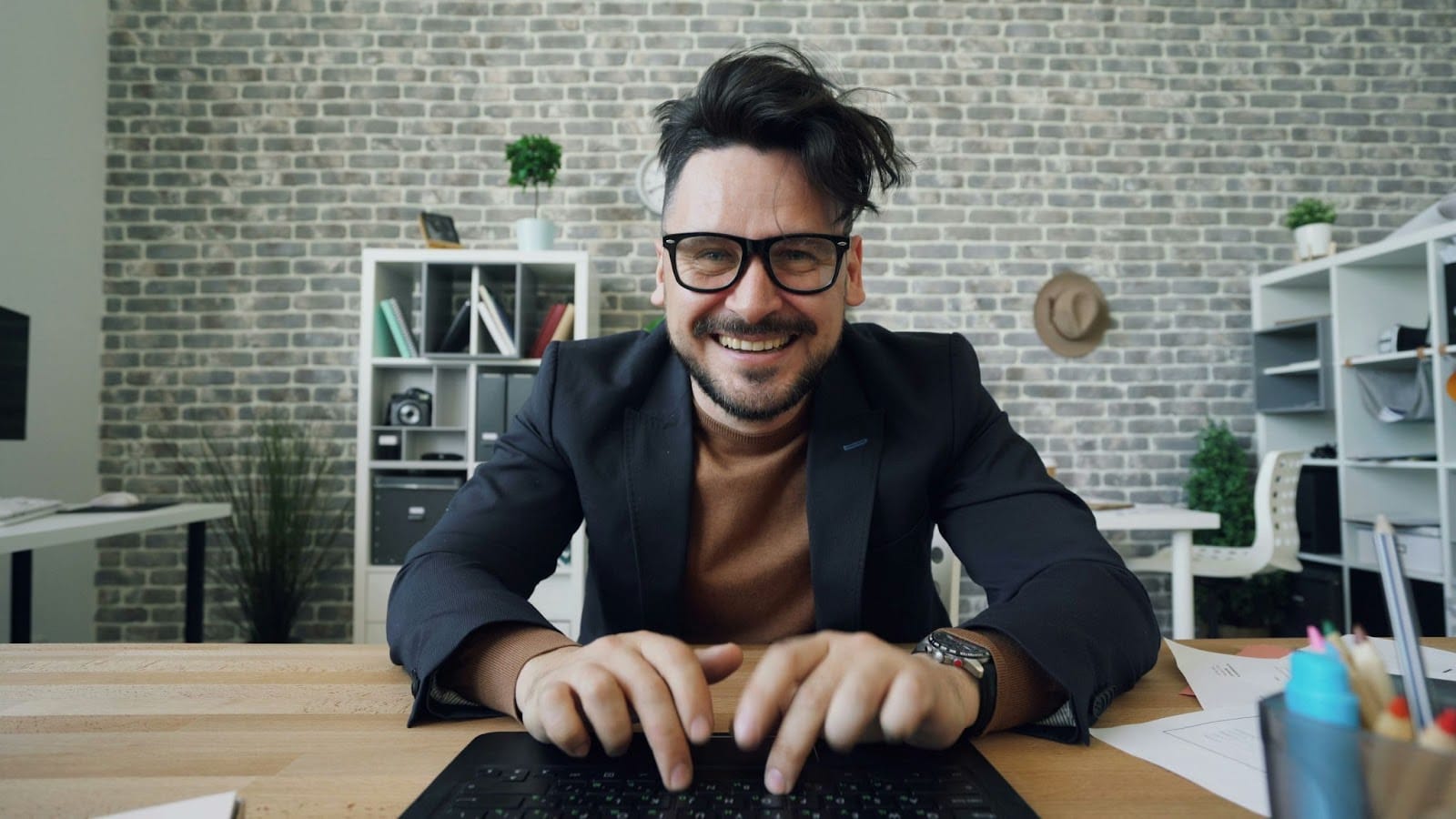 A man smiling while typing on a keyboard.