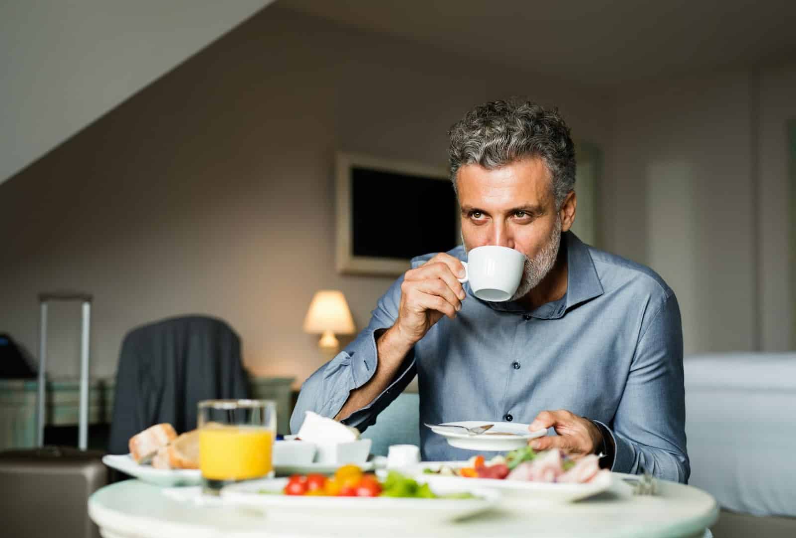 A man drinking coffee instead of eating breakfast.