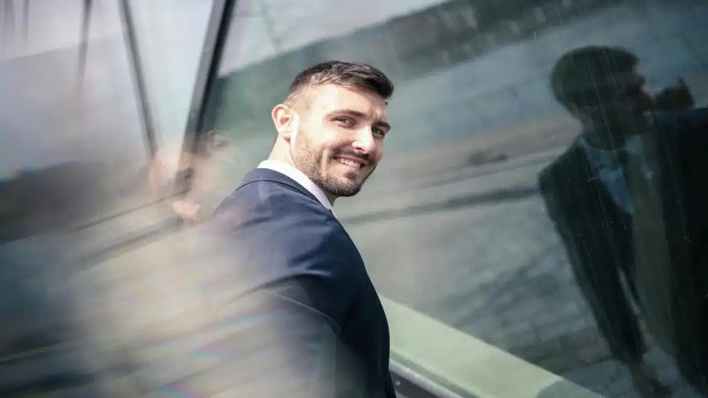 A man wearing a suit and smiling at the camera.