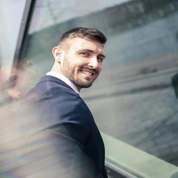 A man wearing a suit and smiling at the camera.