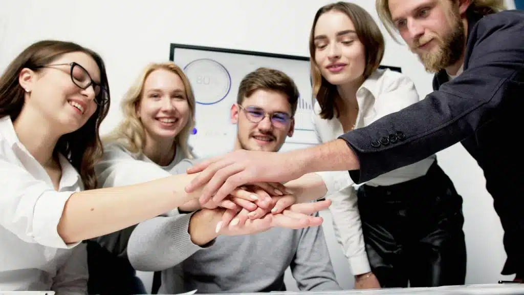 A group of colleagues huddle during a meeting.
