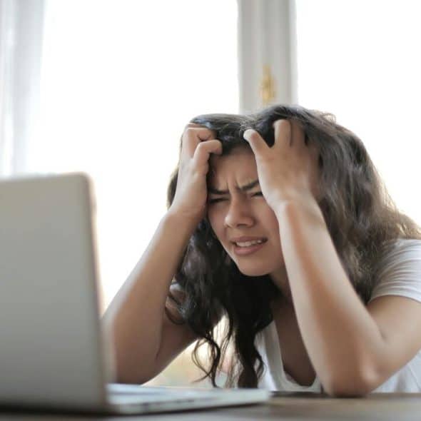A woman frustrated in front of her laptop.