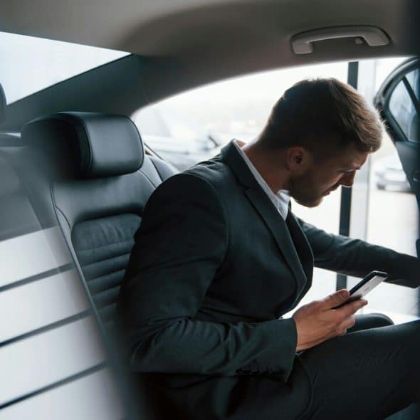 A businessman entering his car.