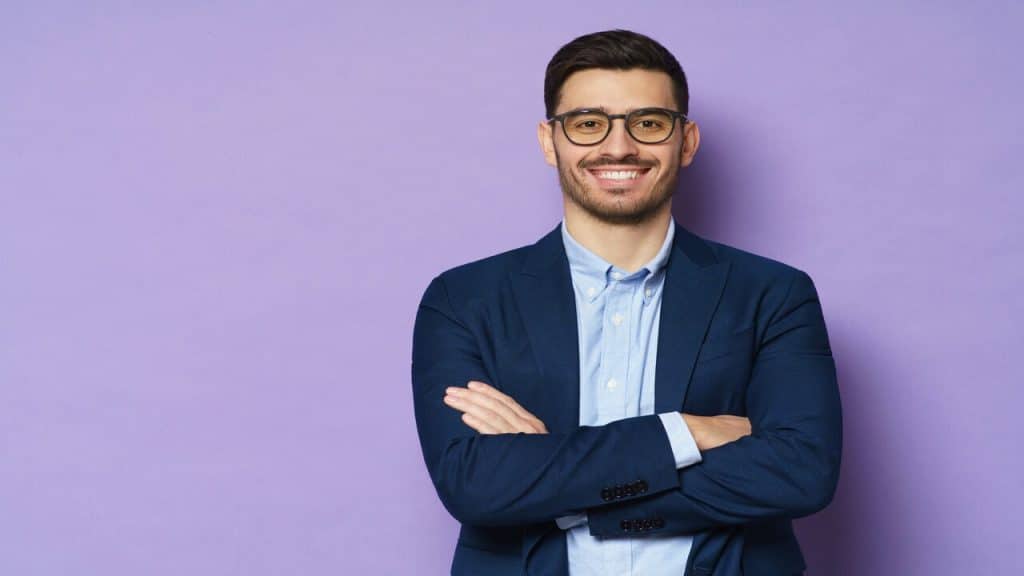 A man smiling and wearing business casual.